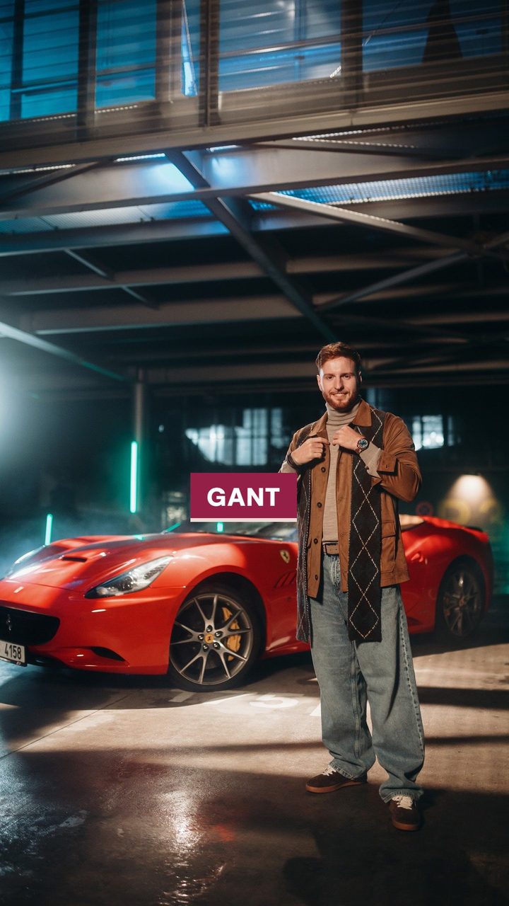 Popisek GANT u bundy v garáži s červeným autem